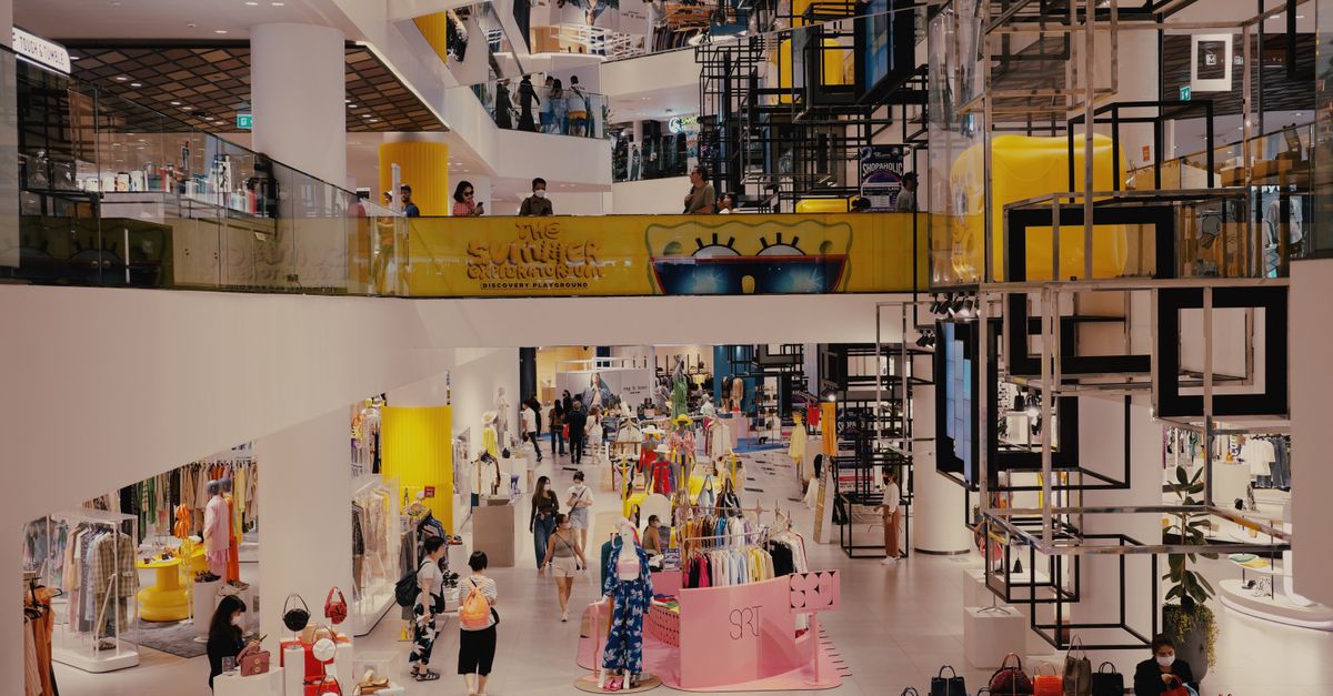 Vibrant mall filled with shoppers, contemporary decor, and stylish fashion outlets.